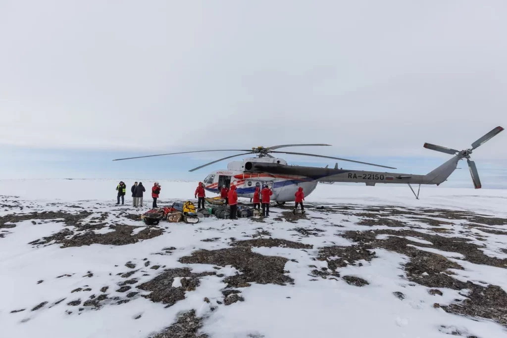 Участники экспедиции загружаются на вертолёт